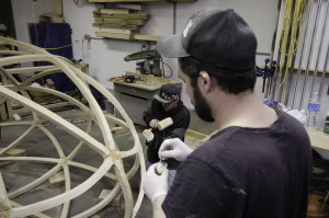 Mixing glue while Brian hammers in dowels.